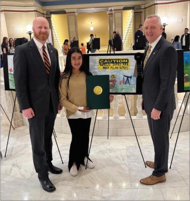 Navajo Elementary student Lizbeth Granado was selected as a winner of the Oklahoma Energy Resources Board’s Well Site Safety Day Art Contest. Granado is pictured with Brent Howard (left) and Gerrid Kendrix (right). Courtesy photo